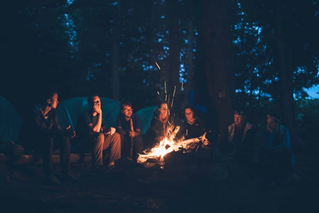 People gathered around a fire at dusk